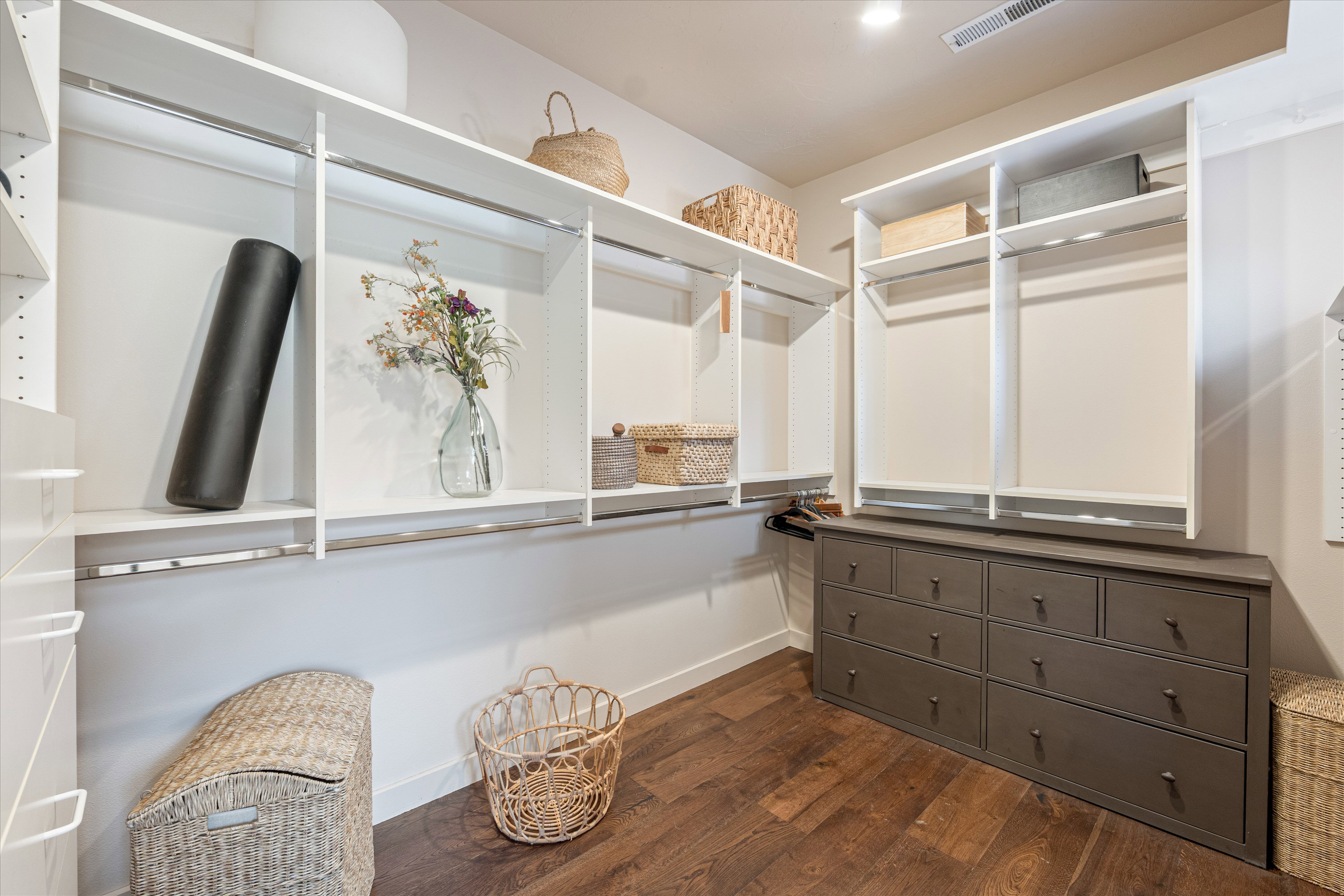 Custom closet organization system featuring white shelving and hanging rods