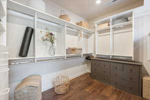 Custom closet organization system featuring white shelving and hanging rods