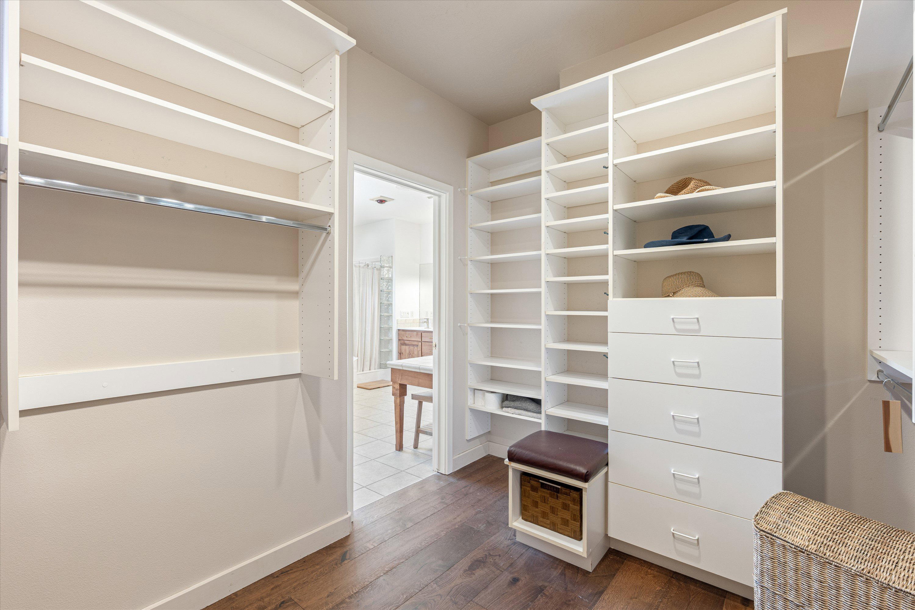 Custom closet system featuring extensive shelving, built-in drawers, and a hanging rod