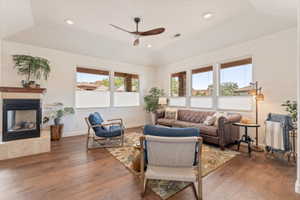 Living area featuring ceiling fan, hardwood / wood-style floors, vaulted ceiling, recessed lighting, and a tiled fireplace
