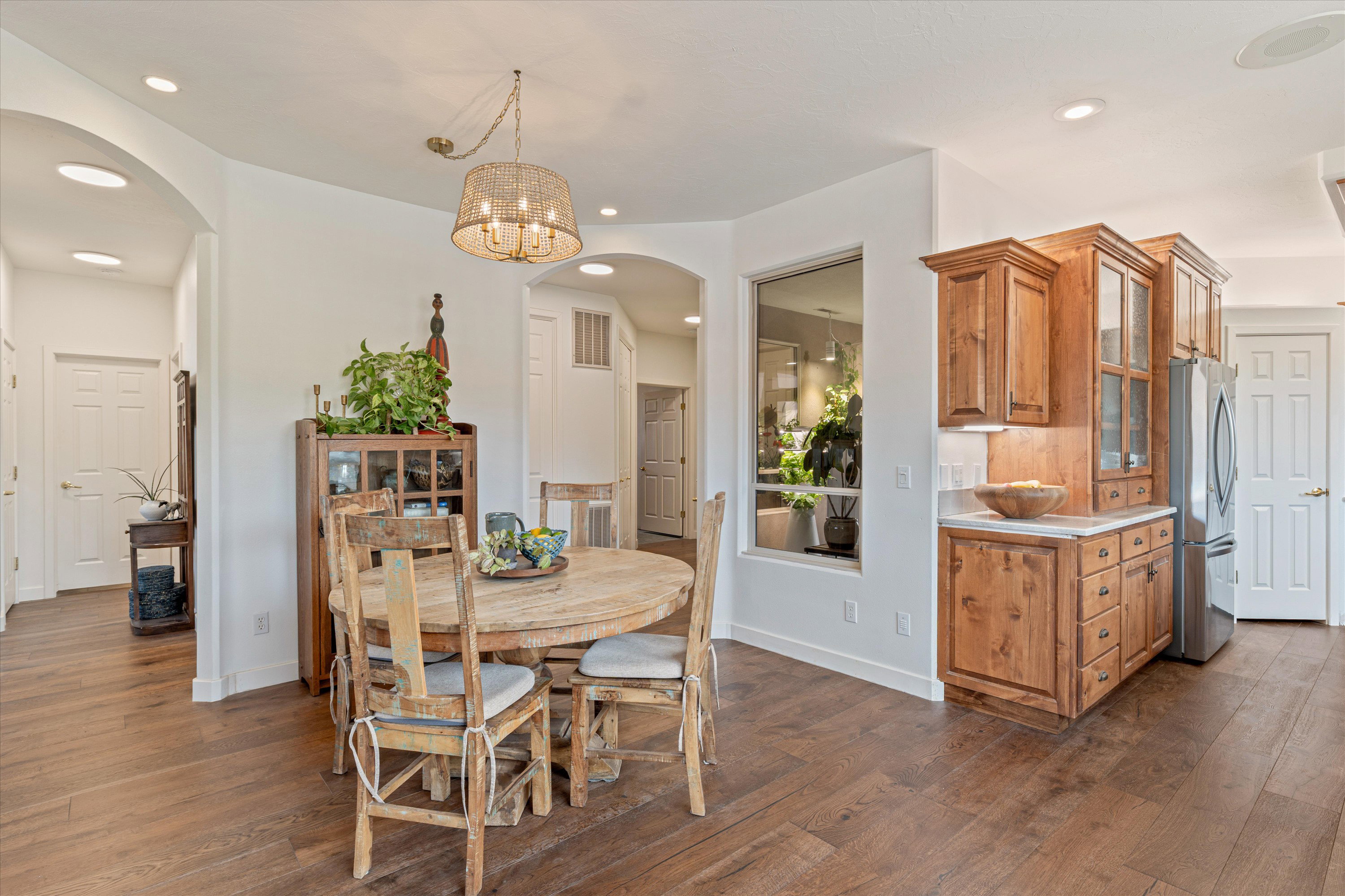 Dining space with arched walkways, dark wood finished floors, and hanging lights