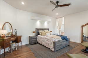 Spacious room featuring wood-finish flooring, a contemporary ceiling fan, recessed lighting, and a white wall-mounted unit