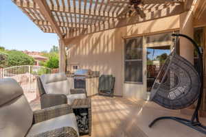 View of patio featuring area for grilling, a ceiling fan, and a pergola