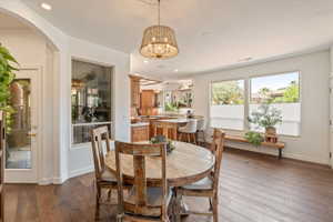 Dining space with hardwood / wood-style flooring and suspended lighting