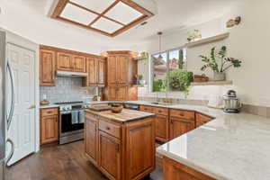 Kitchen featuring butcher block countertops, open shelves, stainless steel appliances, wood finish cabinets, and dark wood-style flooring