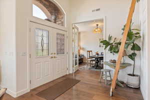 Foyer entrance featuring dark wood-type flooring and hanging lights