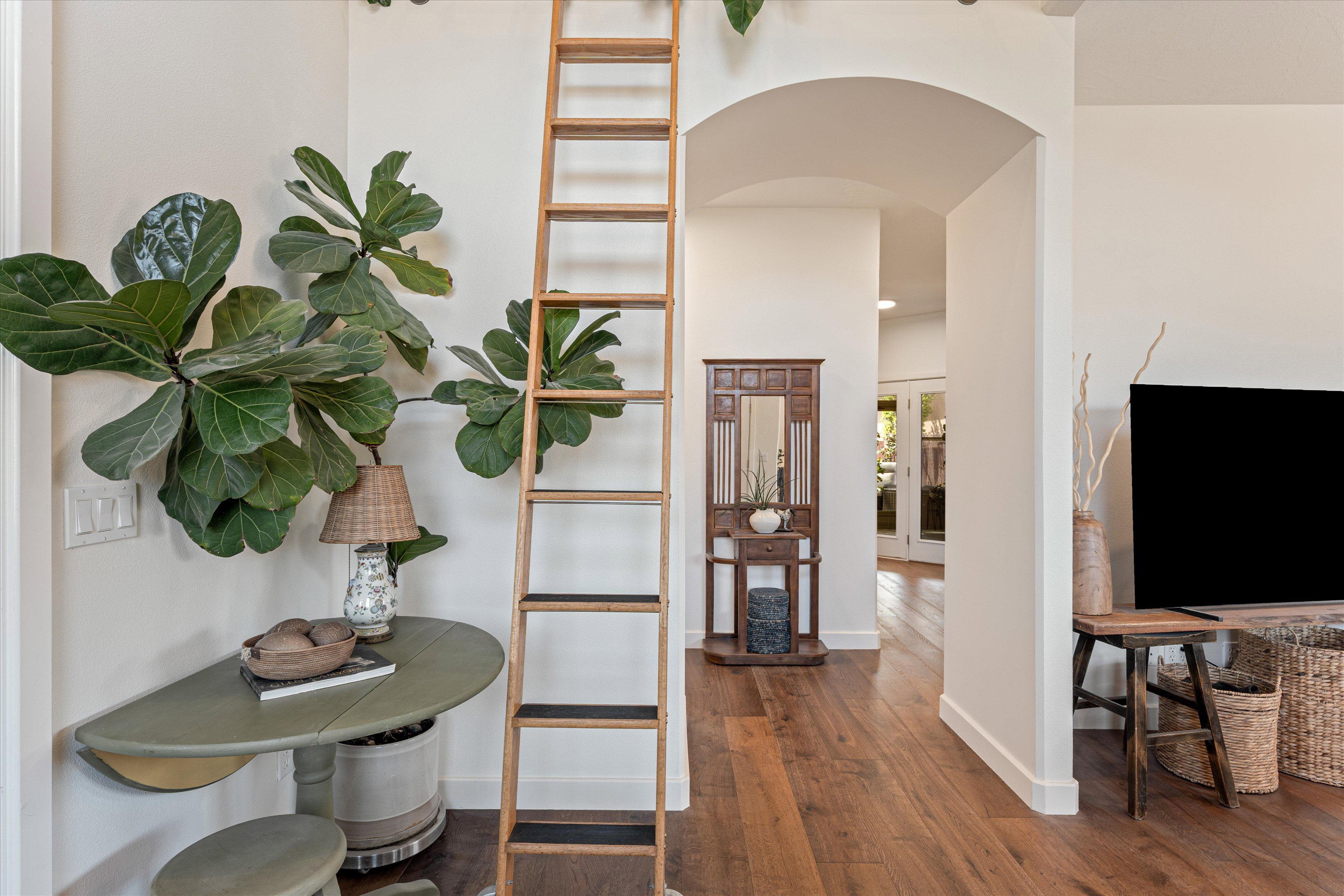 Hallway with arched walkways, dark wood-style floors, and french doors