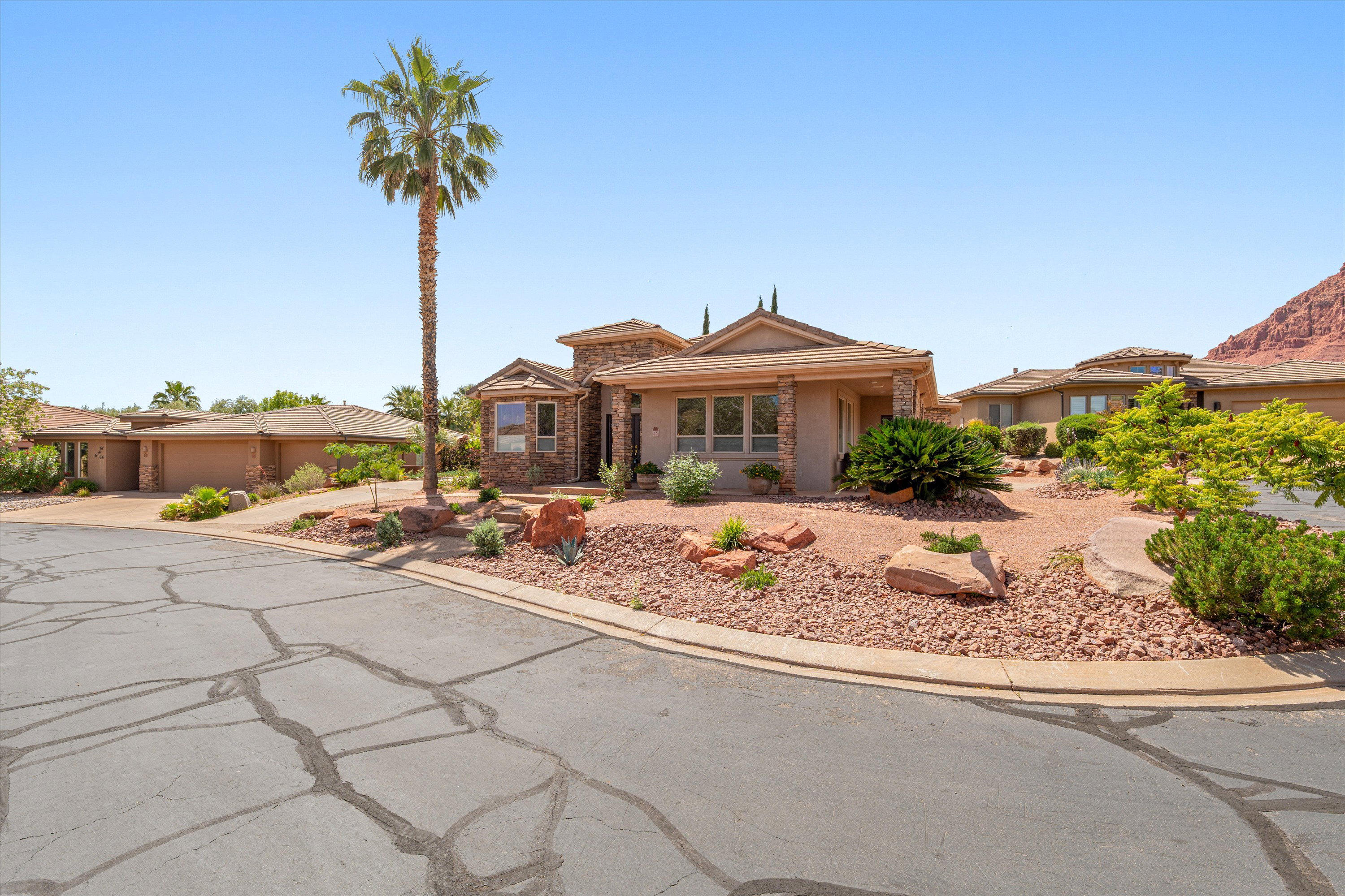 View of front of home featuring stucco siding and stone siding