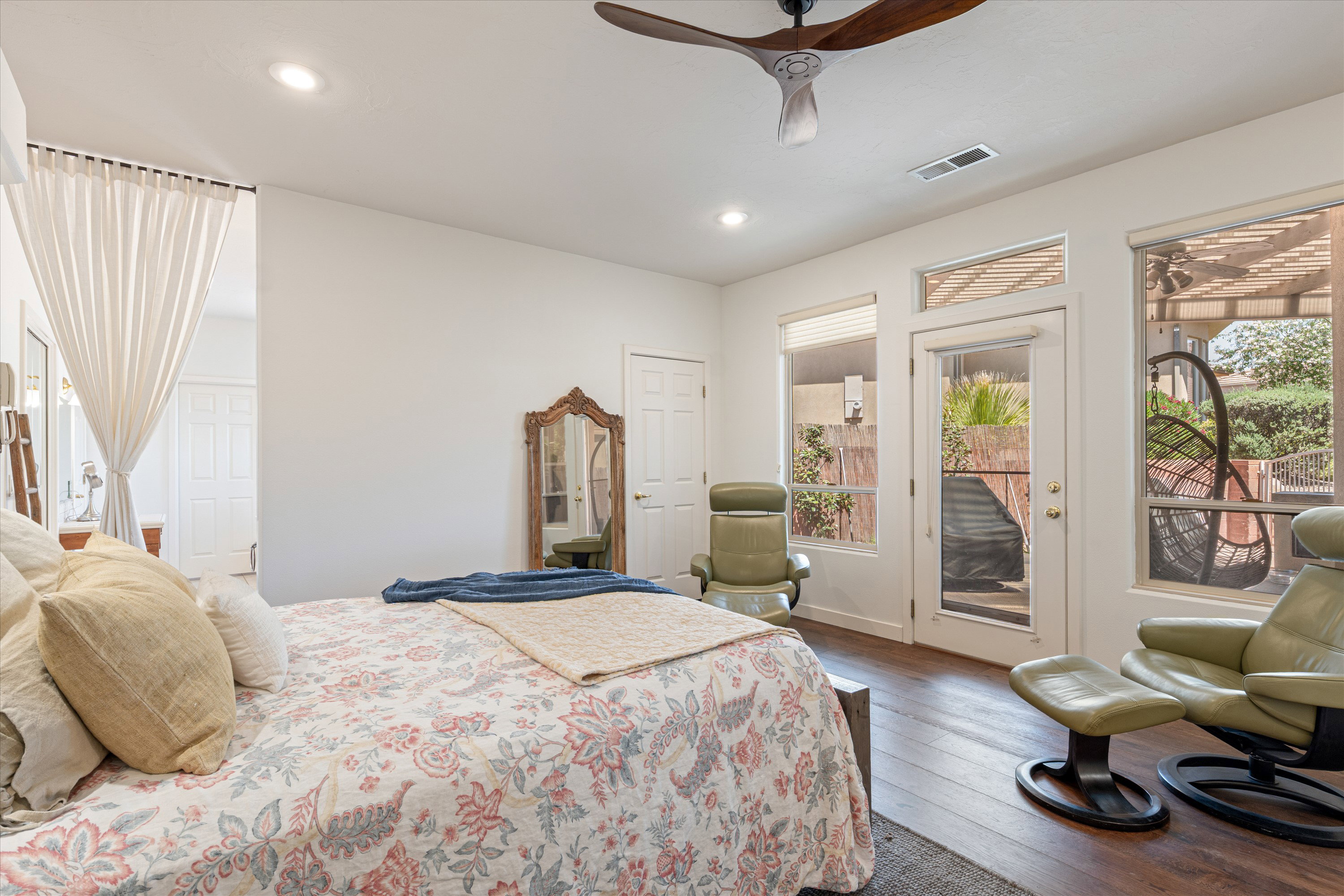 Spacious room featuring wood-finish flooring, a contemporary ceiling fan, recessed lighting, and a glass-paneled door opening to the exterior