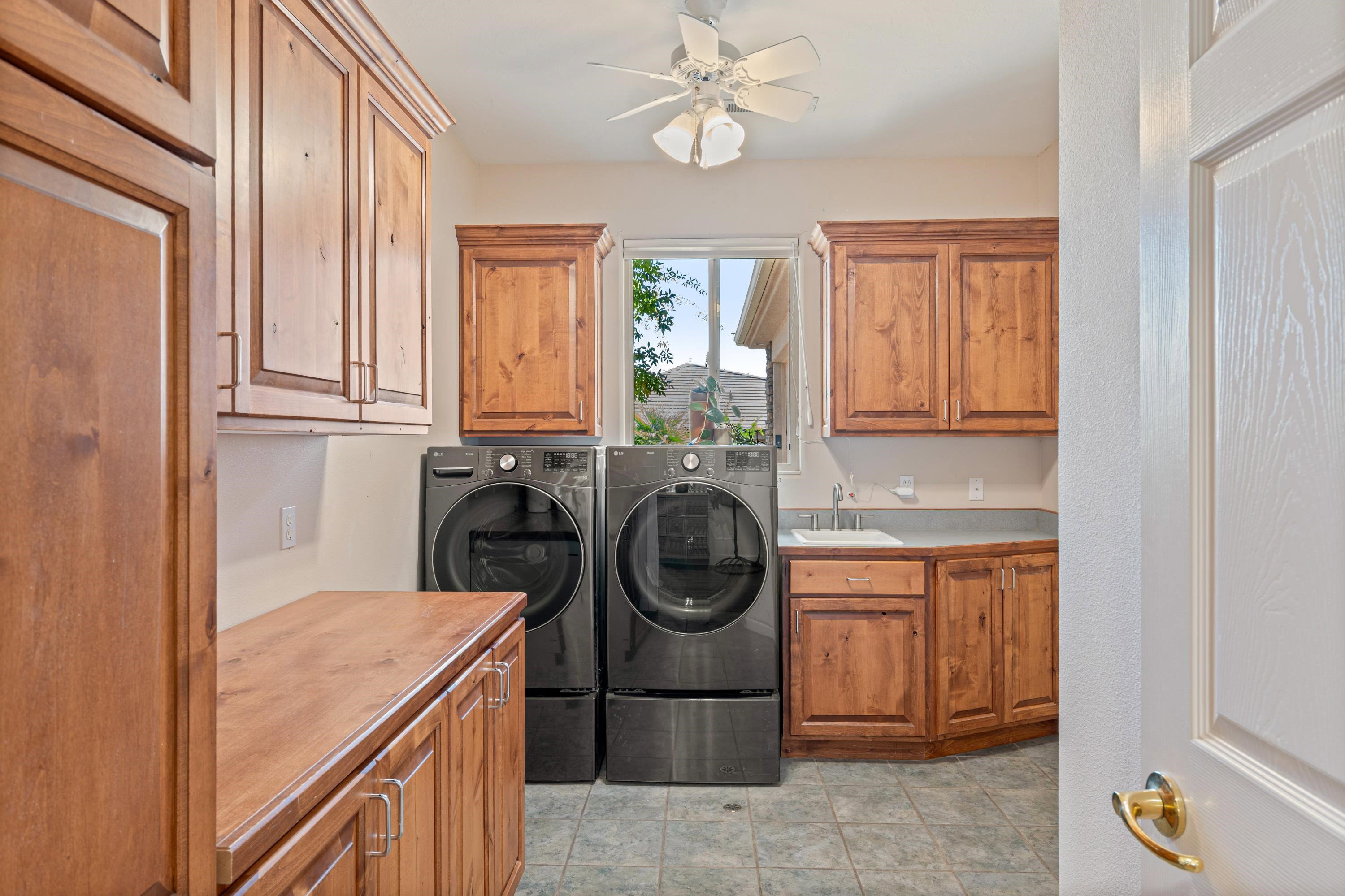 Laundry area with ceiling fan, separate washer and dryer, and cabinet space