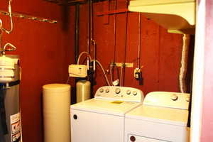 Laundry area featuring independent washer and dryer and water heater and water softener