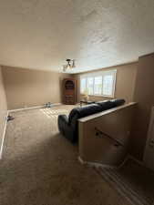 Spacious living area featuring neutral wall tones and textured ceilings