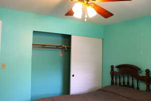 Bedroom with a ceiling fan and a closet