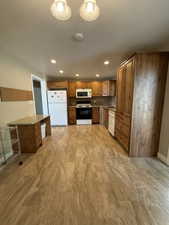 Open-concept kitchen featuring extensive wood cabinetry, granite-finish countertops, a mosaic tile backsplash, and a full suite of appliances