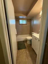 Full bathroom featuring a white vanity with integrated sink, a white bathtub, and tile flooring