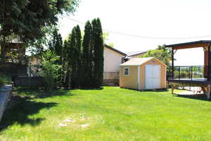 Fenced backyard featuring a storage shed