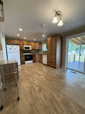 Kitchen featuring wood cabinetry, stone-look tile flooring, and a tile backsplash