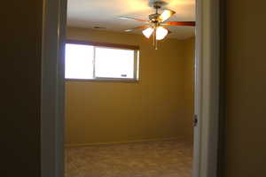 Unfurnished room featuring a ceiling fan and carpet floors