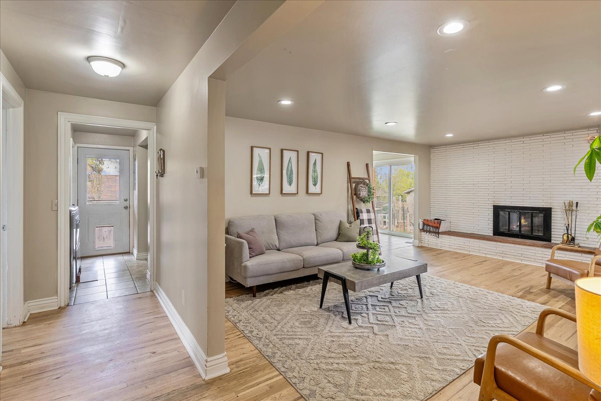 Living room featuring light wood-type flooring, a fireplace, and recessed lighting