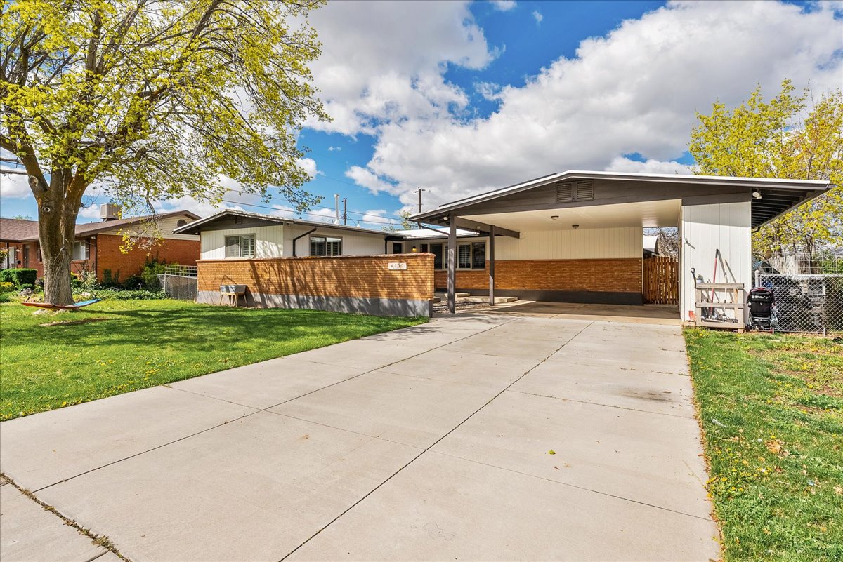 View of front of house featuring driveway and brick siding