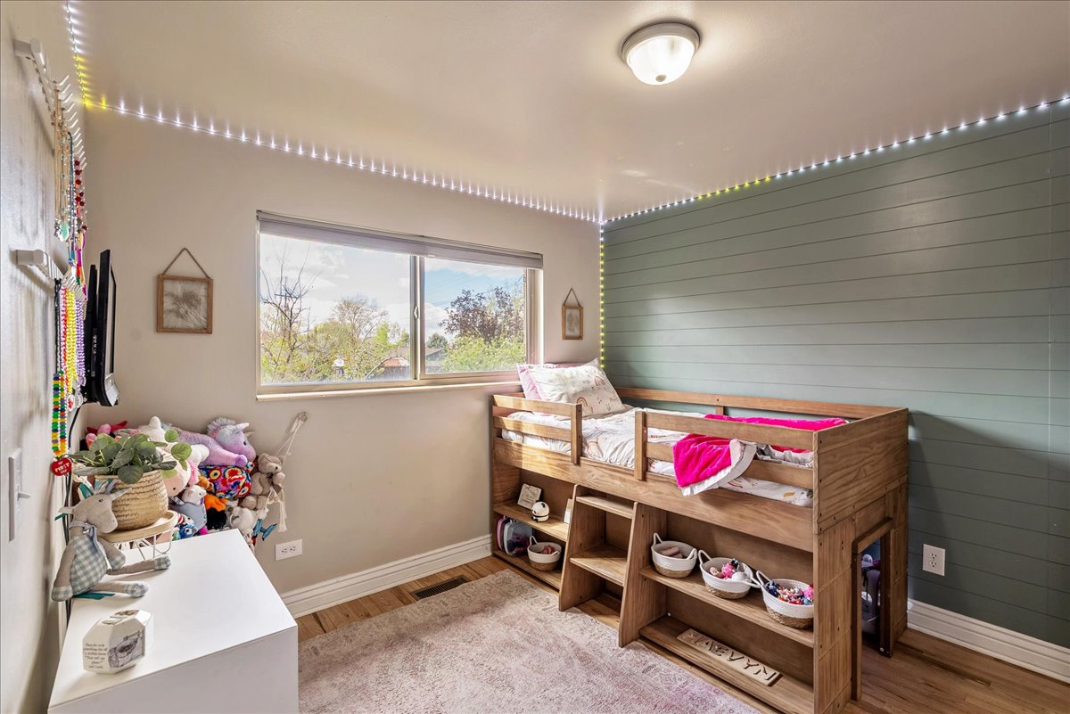 Bedroom featuring light wood finished floors and wood walls
