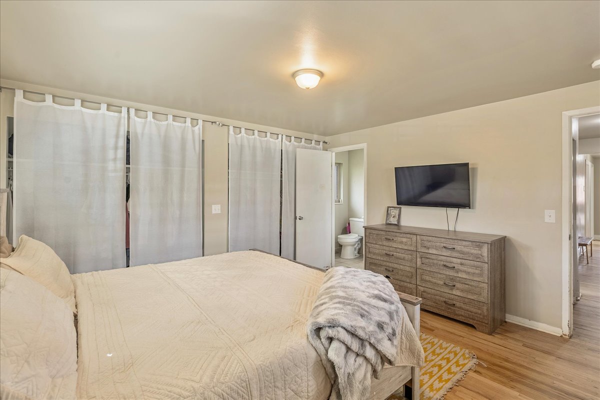 Bedroom featuring wood finished floors and ensuite bathroom