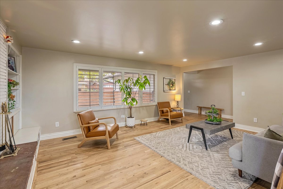 Living area featuring light wood finished floors, recessed lighting, and a fireplace with raised hearth