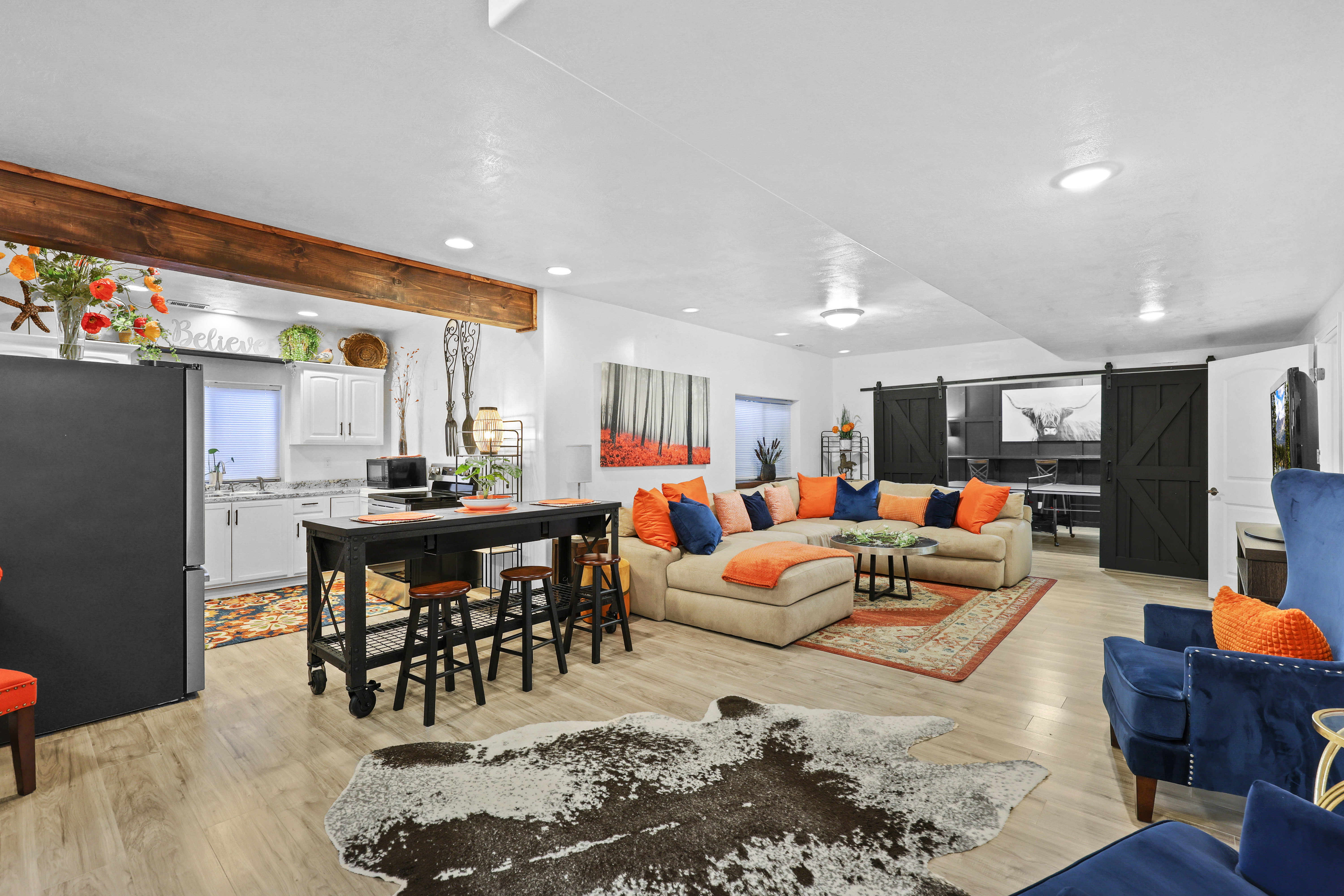 Living room featuring a barn door, light wood-style floors, and recessed lighting