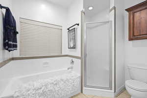 Full bath with a shower stall, light tile patterned floors, and a bath