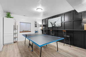 Rec room featuring light wood-style flooring and a textured ceiling