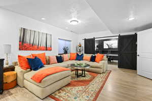 Living room featuring a barn door and wood finished floors