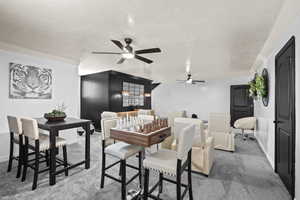 Carpeted dining space featuring baseboards and ceiling fan