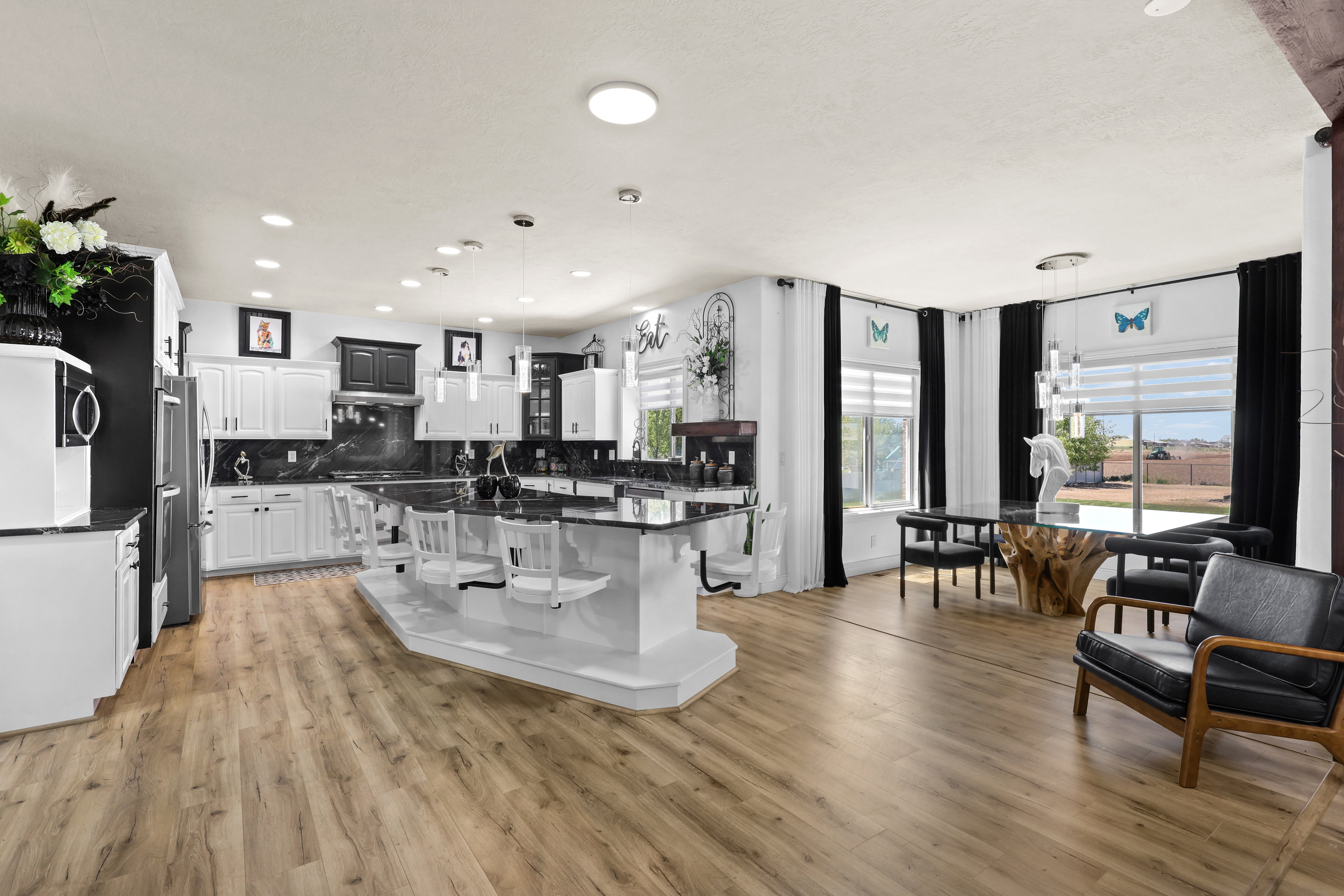 Kitchen with a kitchen island, white cabinets, tasteful backsplash, pendant lighting, and light wood finished floors