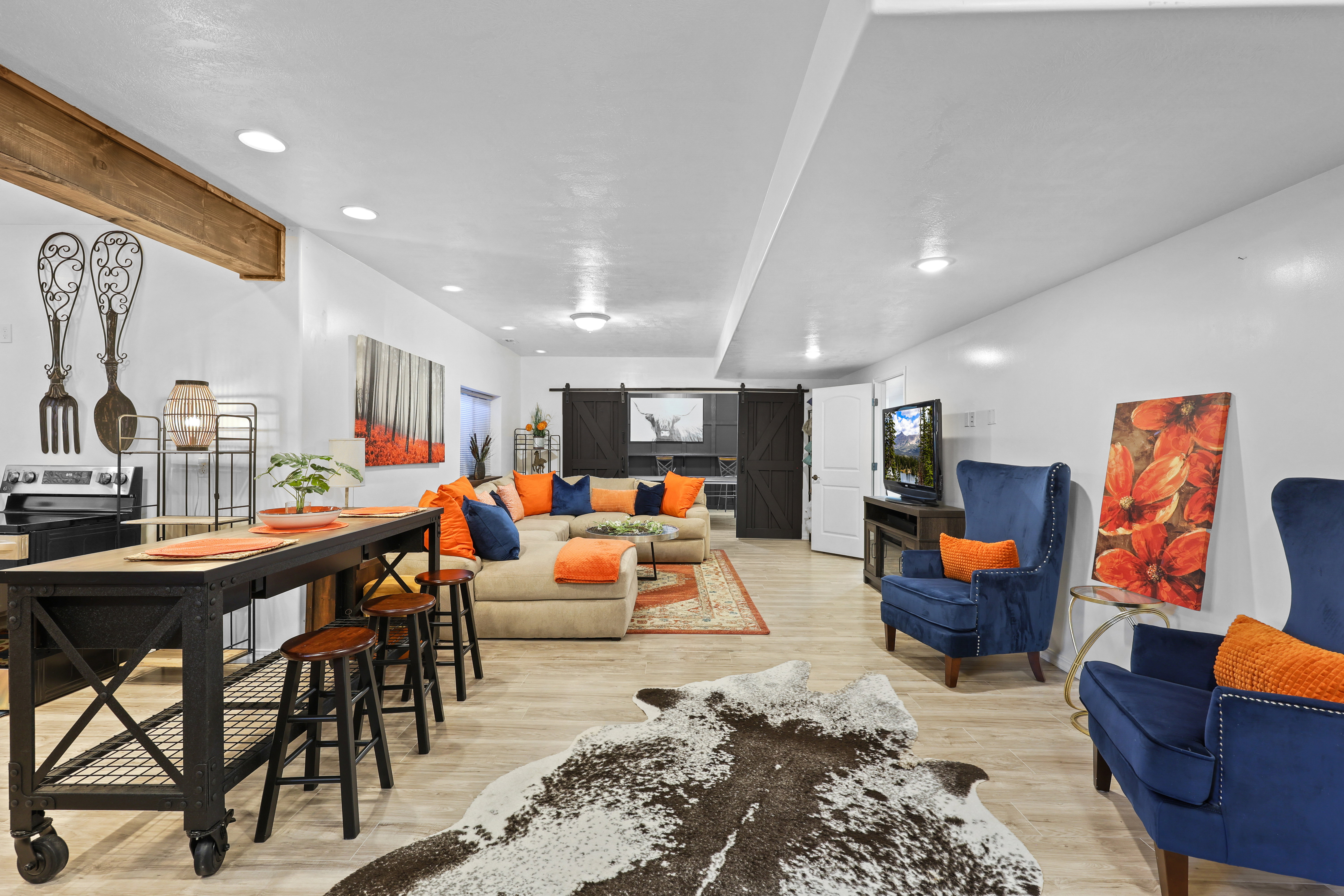 Living room featuring a barn door, light wood finished floors, and recessed lighting