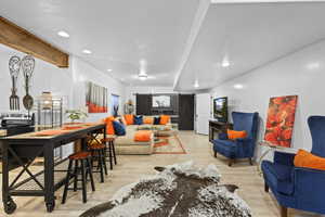 Living room featuring a barn door, light wood finished floors, and recessed lighting