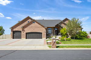 French provincial home with brick siding, an attached garage, a front yard, driveway, and a porch