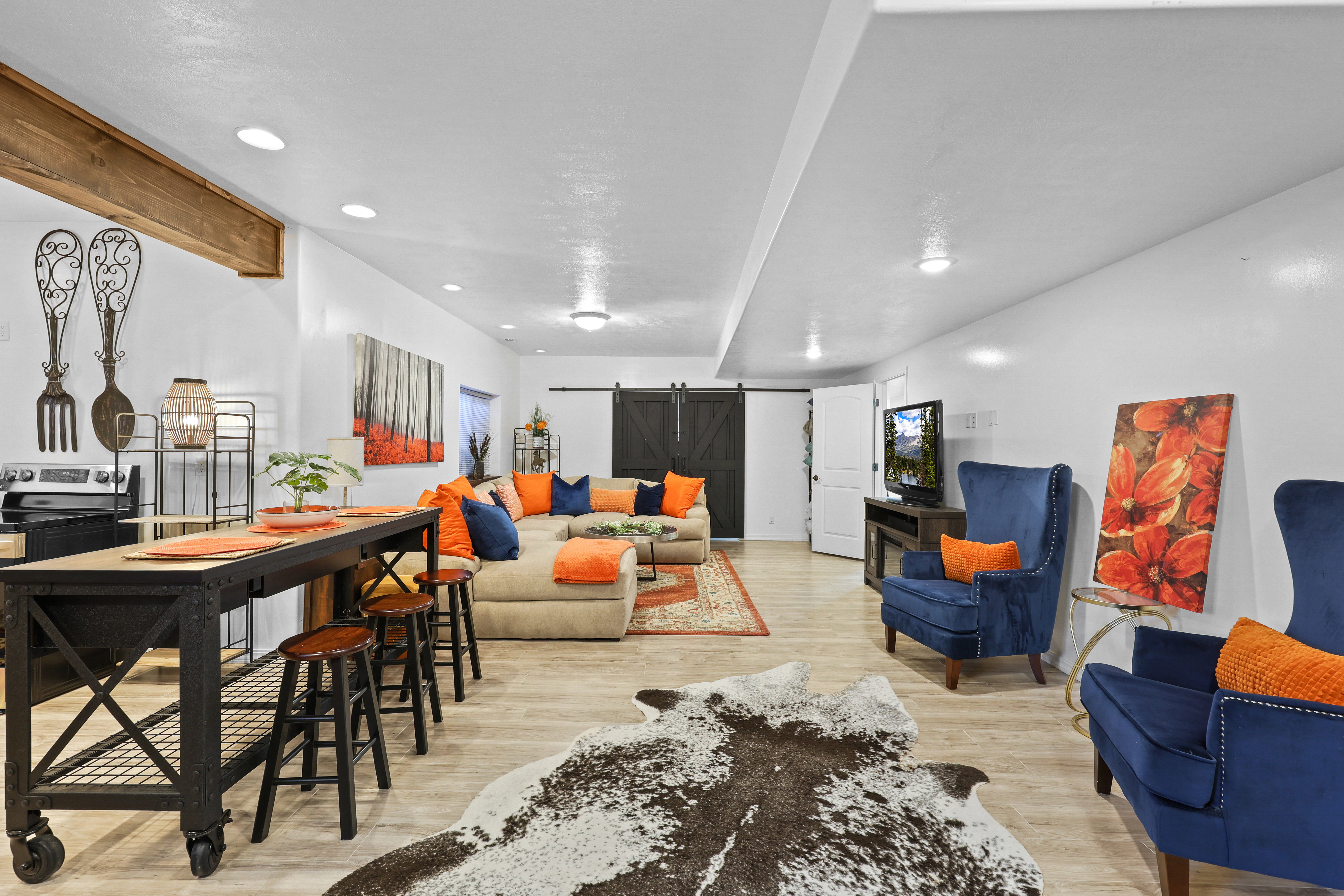 Living area featuring a barn door, light wood-style flooring, and recessed lighting