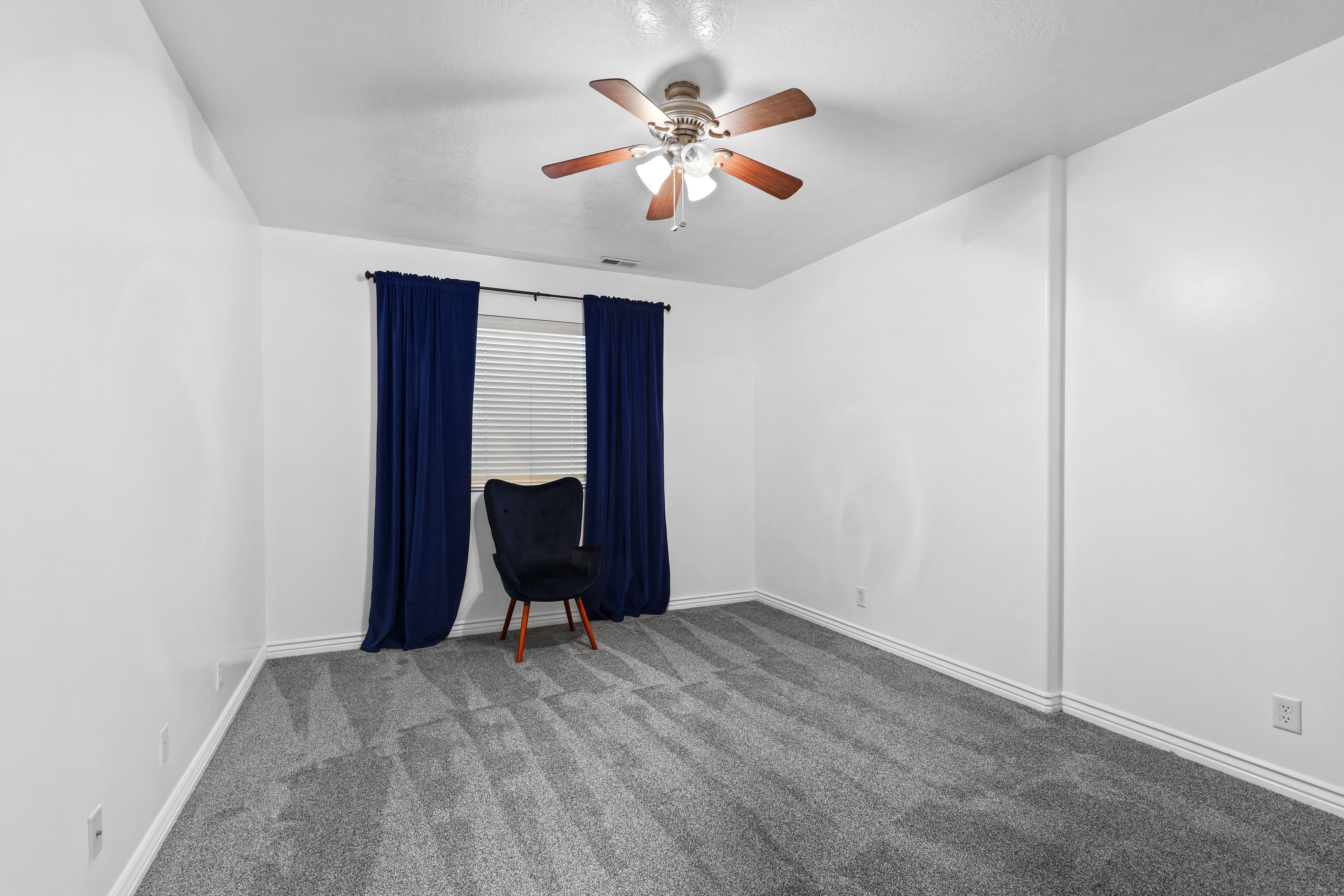 Unfurnished room with carpet and a ceiling fan