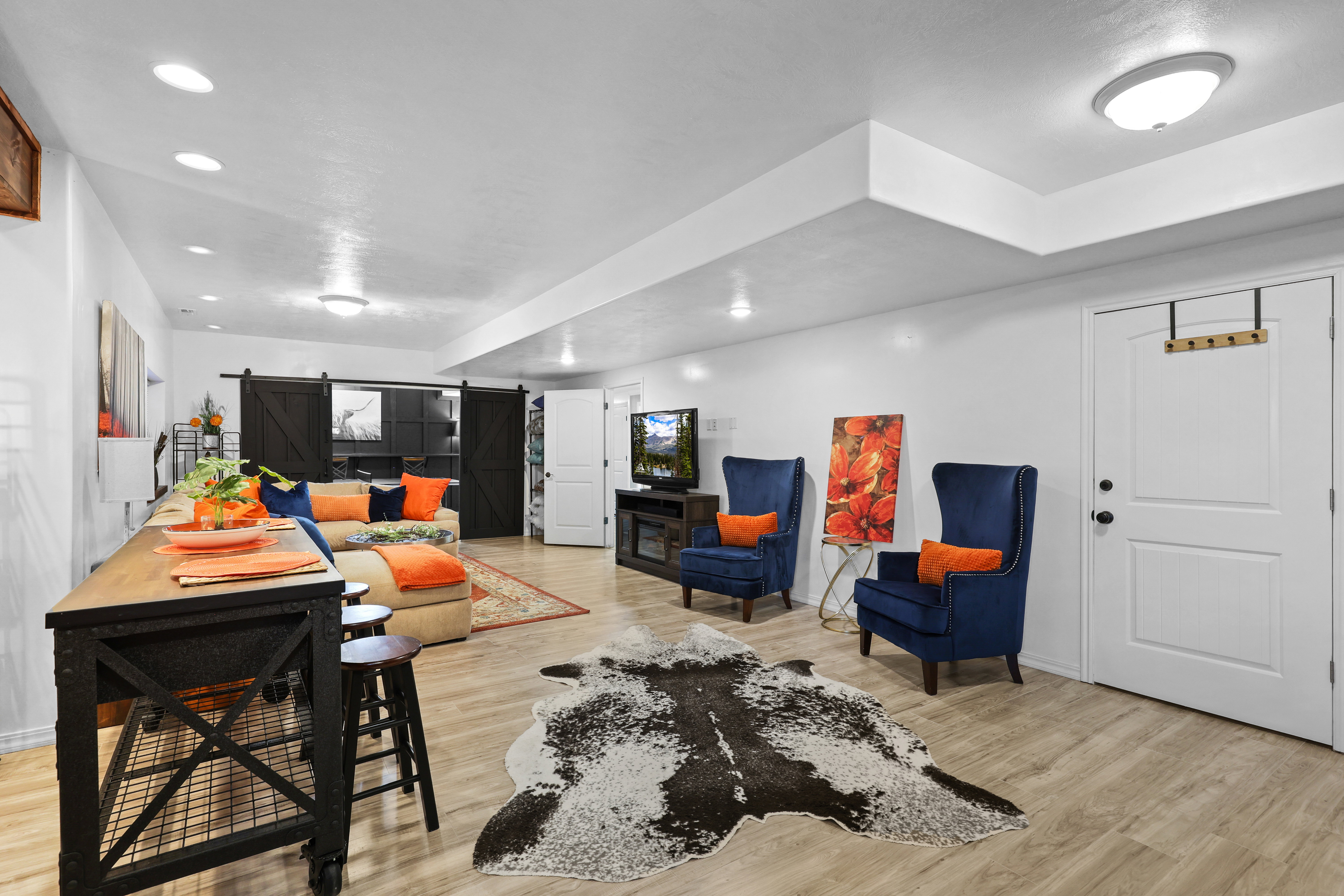 Living room featuring a barn door, light wood finished floors, and recessed lighting