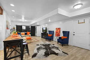 Living room featuring a barn door, light wood finished floors, and recessed lighting