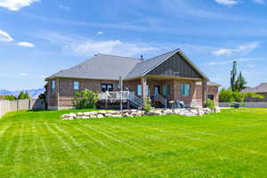Rear view of house with a fenced backyard, brick siding, a ceiling fan, board and batten siding, and a patio area