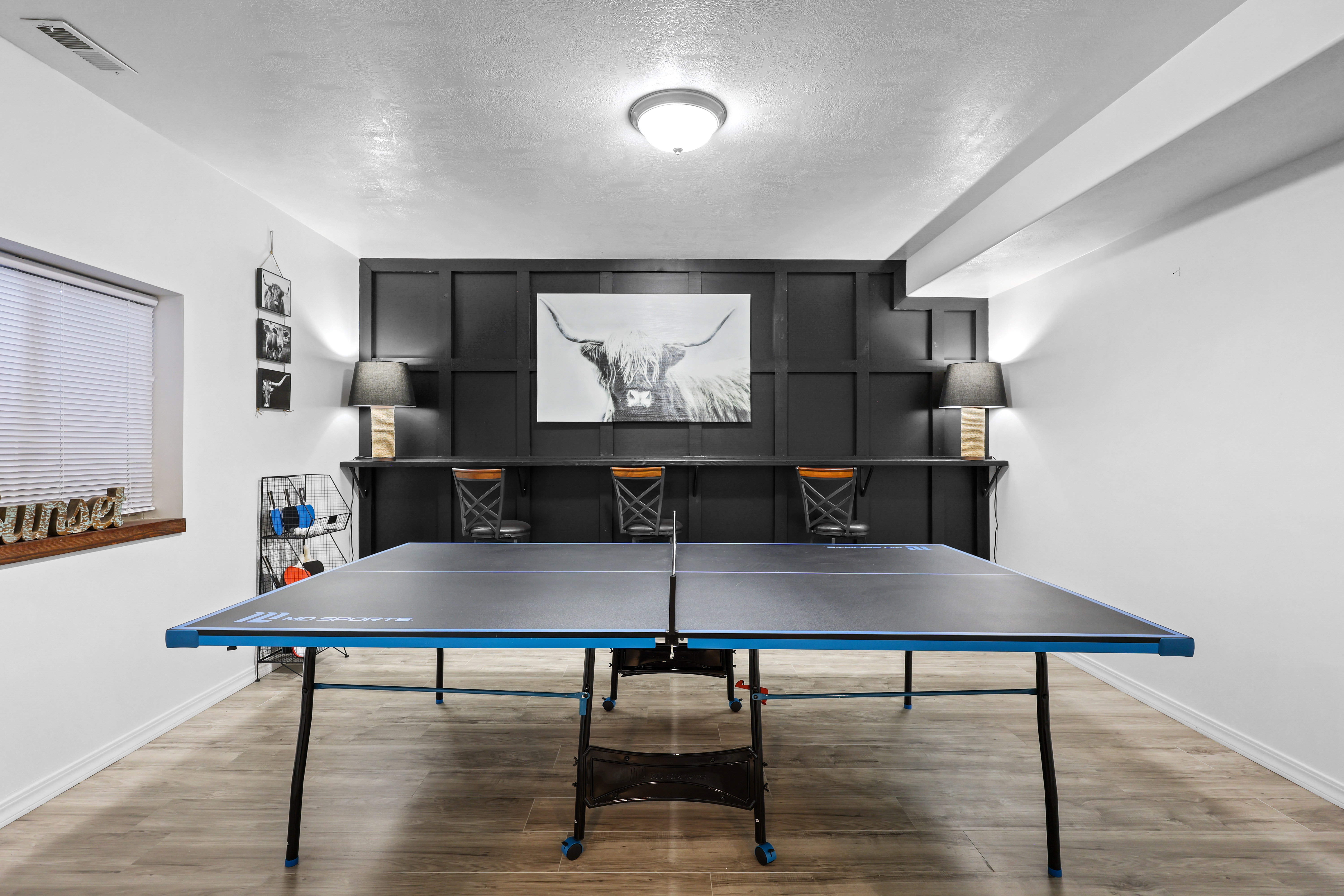 Recreation room with light wood-type flooring and a textured ceiling