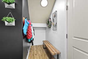 Doorway with wood finished floors and lofted ceiling
