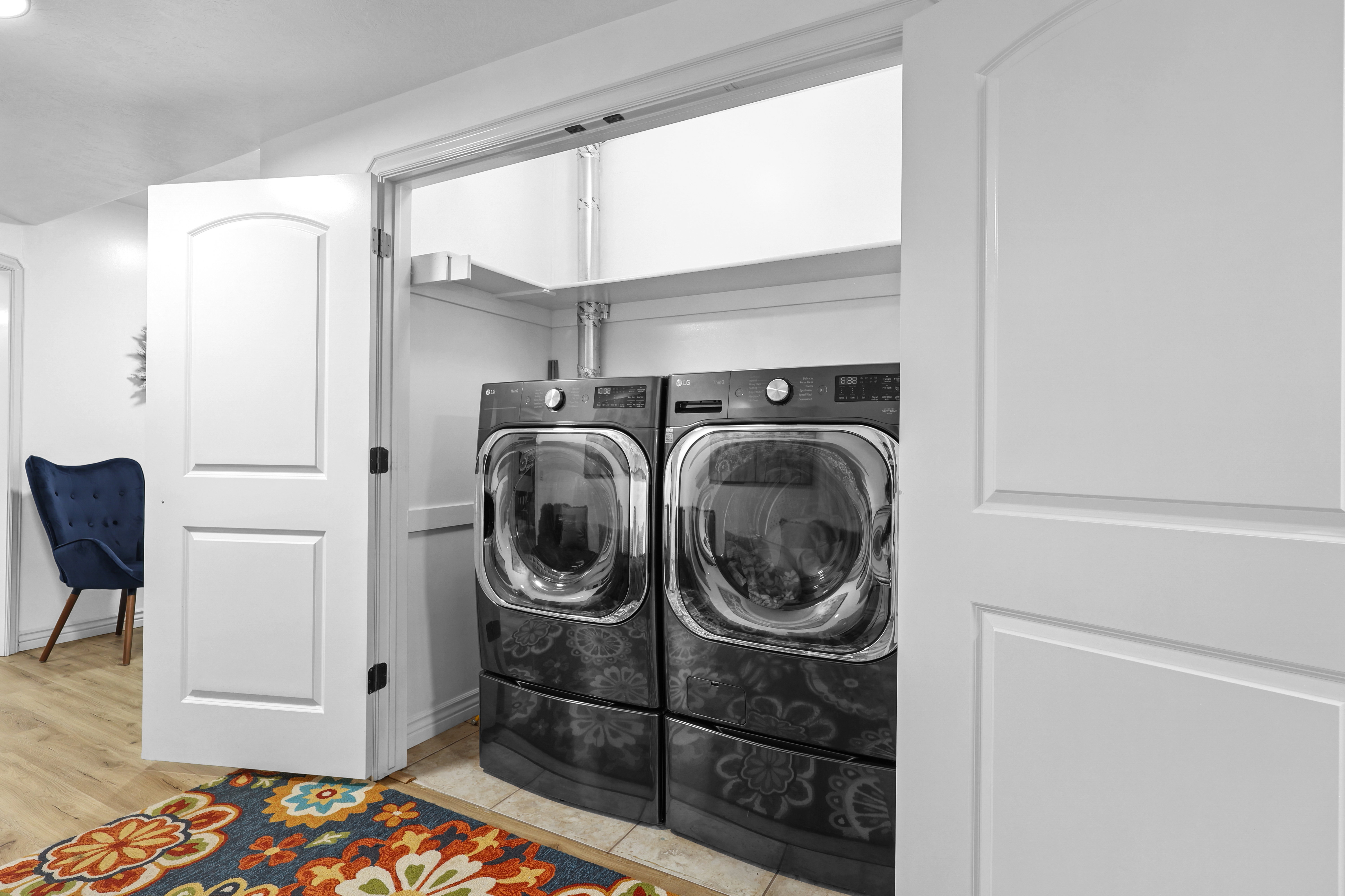 Laundry area with washer and clothes dryer and light wood-style flooring