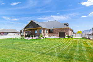 Back of property with a fenced backyard, brick siding, a ceiling fan, a patio area, and a mountain view