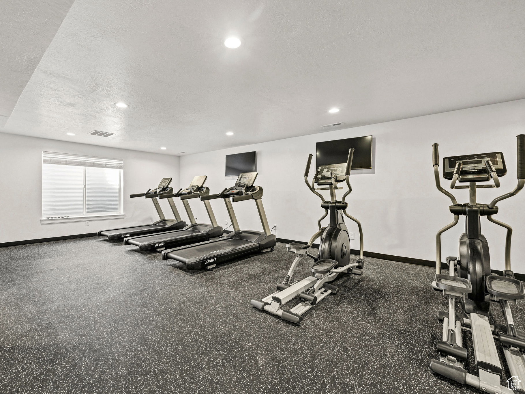 Workout area featuring a textured ceiling and recessed lighting