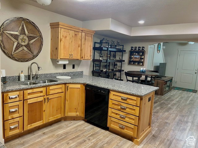 Kitchen featuring a peninsula, light wood finished floors, light stone countertops, dishwasher, and recessed lighting
