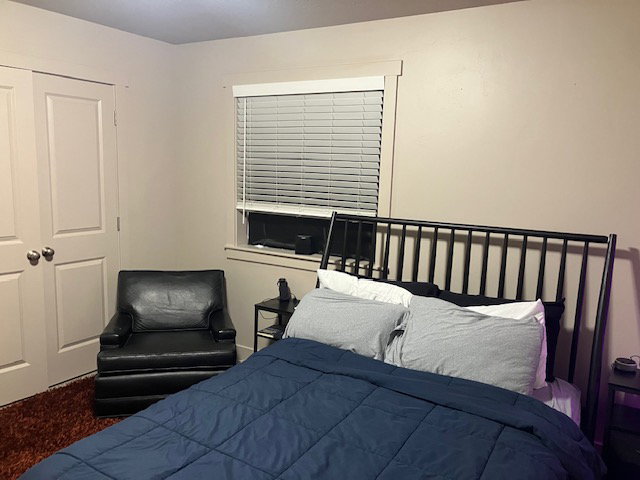Bedroom featuring a window with blinds and white trim