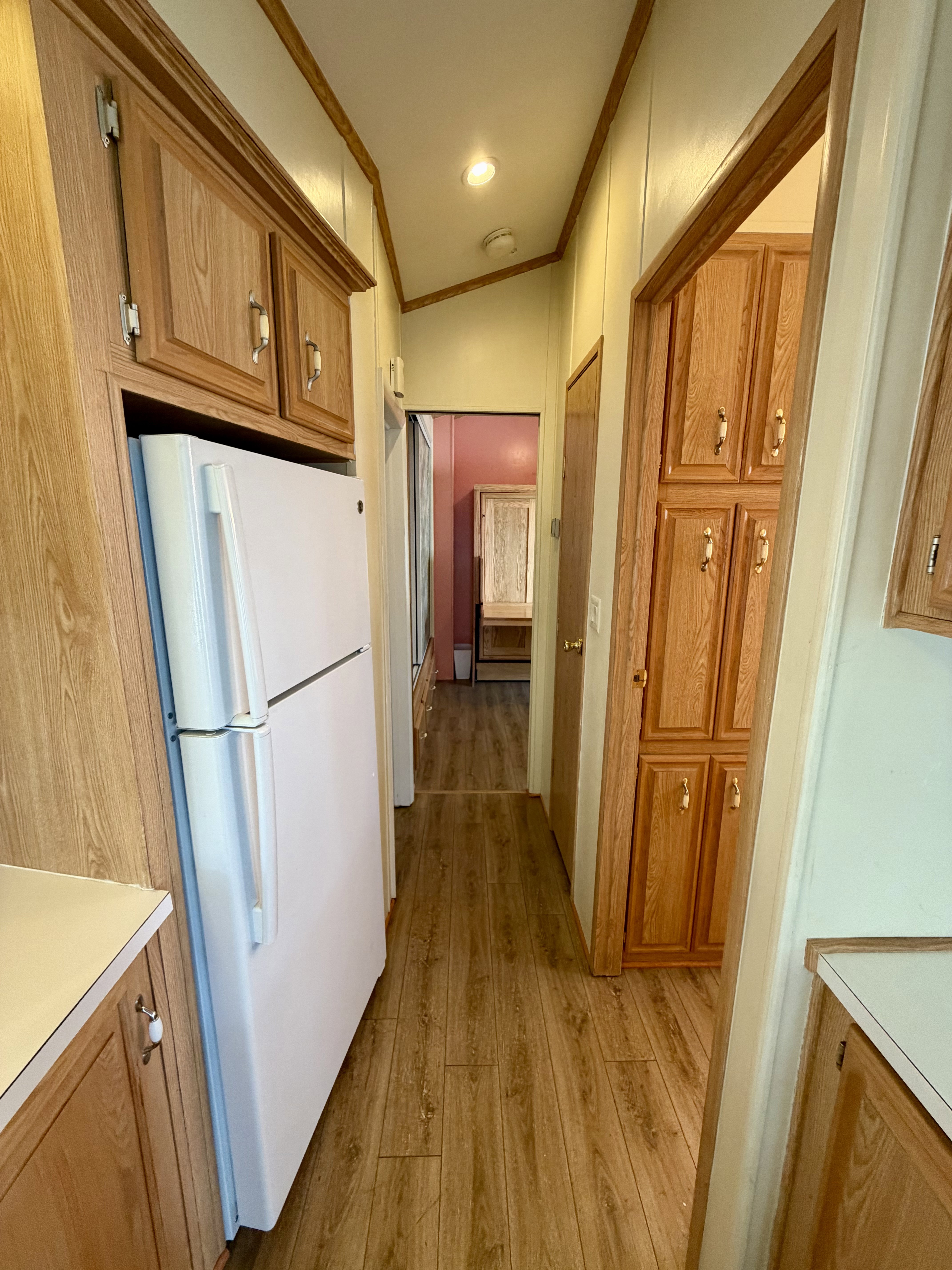 Hall featuring ornamental molding, light wood finished floors, and lofted ceiling