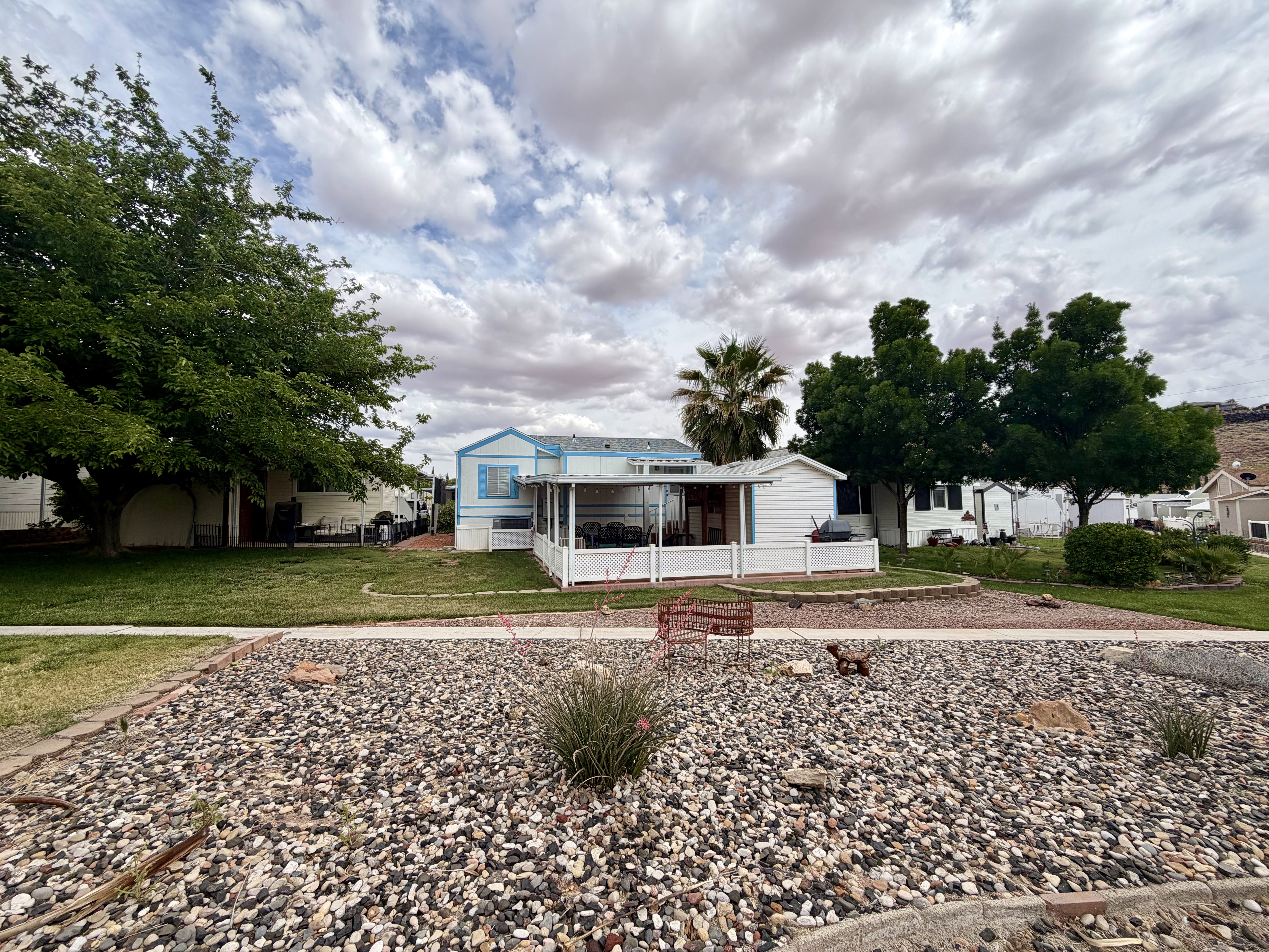 Manufactured / mobile home featuring a front lawn and a sunroom
